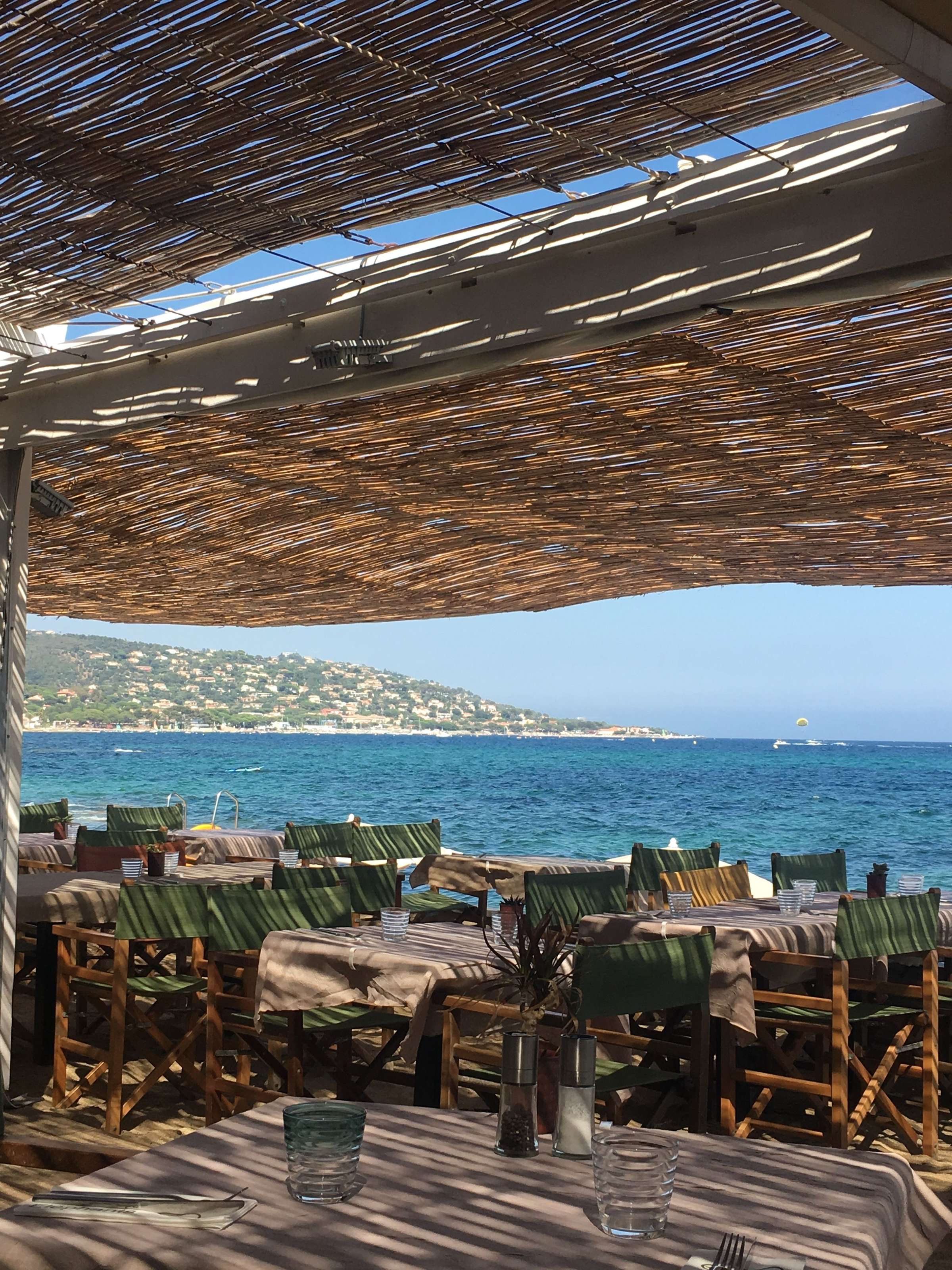 Tables de plage à l’ombre d’une paillote, face à la mer à Saint-Tropez